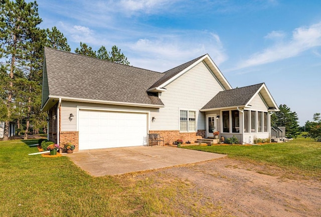 view of front of house featuring concrete driveway, brick siding, a front yard, and a sunroom