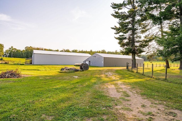 view of yard with an outbuilding, a pole building, a rural view, and fence