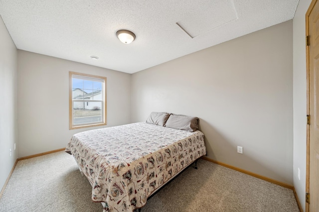 carpeted bedroom featuring a textured ceiling and baseboards