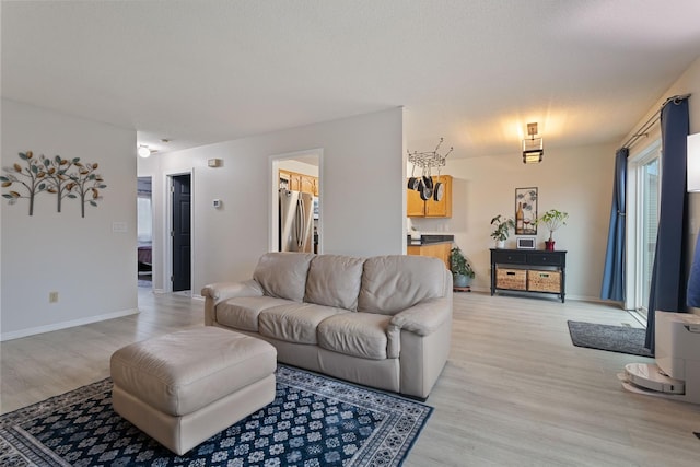 living area with baseboards and light wood finished floors