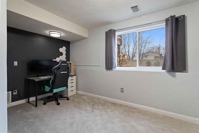 carpeted home office featuring a textured ceiling, visible vents, and baseboards