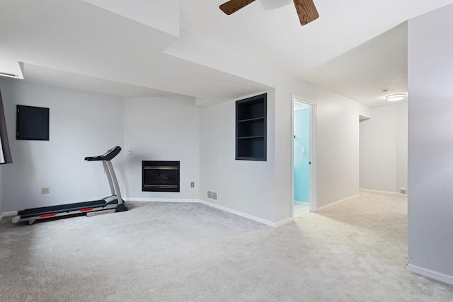 workout room with a fireplace, light colored carpet, visible vents, a ceiling fan, and baseboards