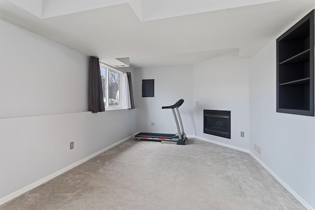 workout area featuring a fireplace, carpet flooring, visible vents, and baseboards