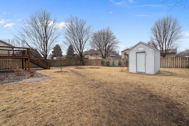 view of yard featuring stairway, a shed, a fenced backyard, an outdoor structure, and a wooden deck