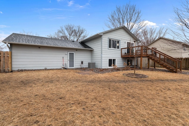 rear view of house with a deck, cooling unit, fence, roof with shingles, and stairway