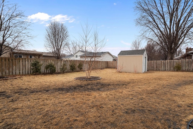 view of yard featuring a fenced backyard, an outdoor structure, and a shed