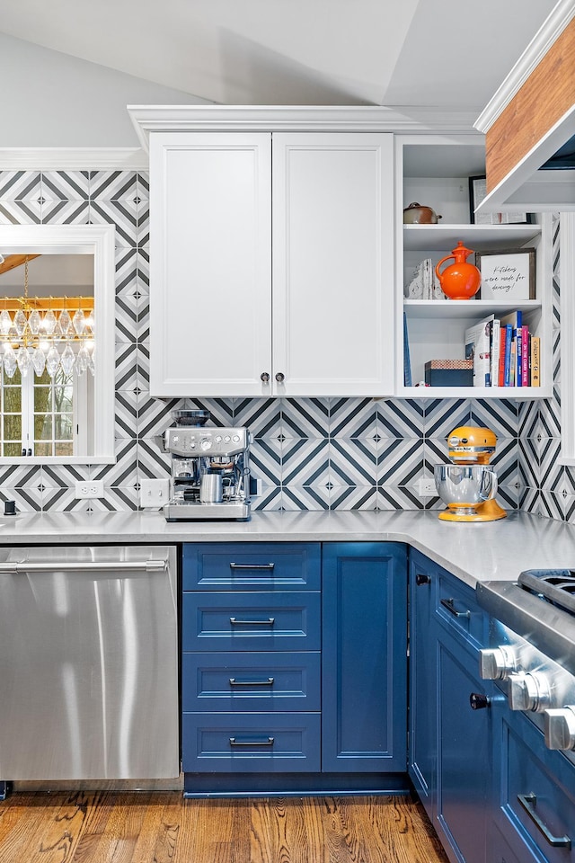 kitchen featuring appliances with stainless steel finishes, blue cabinets, light countertops, open shelves, and backsplash