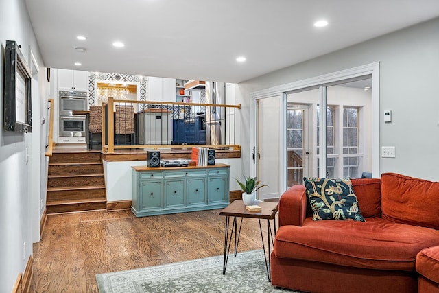 living room featuring dark wood-style floors, stairs, and recessed lighting