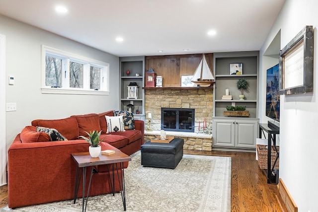 living room with visible vents, built in features, dark wood-style flooring, a fireplace, and recessed lighting