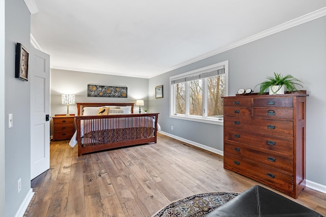 bedroom with wood-type flooring, ornamental molding, and baseboards