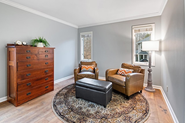 sitting room with light wood-style floors, baseboards, and ornamental molding