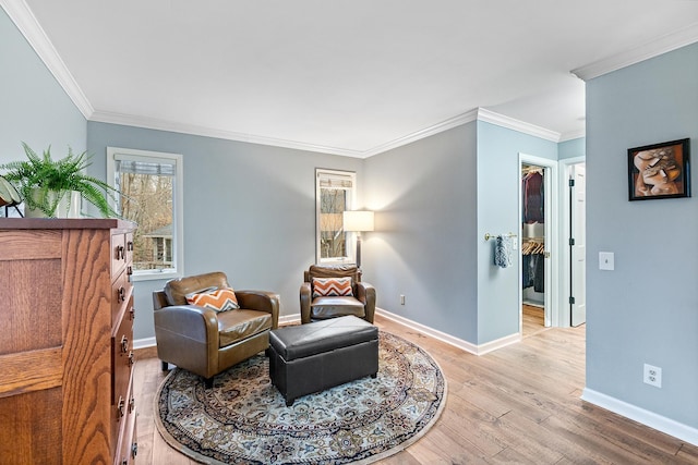 living area with light wood-style flooring, baseboards, and ornamental molding