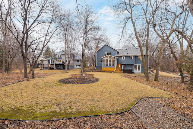 view of front of property featuring driveway, a chimney, and a front lawn