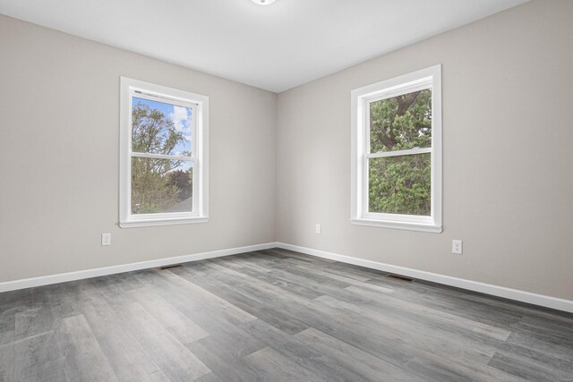 2310 Leona Dr, New Brighton, MN 55112 - empty room featuring plenty of natural light, dark wood finished floors, and baseboards