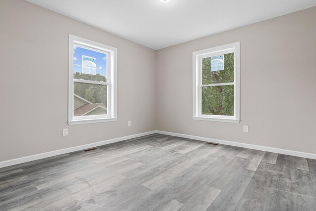 2310 Leona Dr, New Brighton, MN 55112 - unfurnished room featuring healthy amount of natural light, wood finished floors, and baseboards