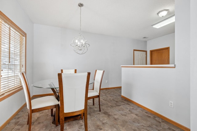 dining area with a notable chandelier and baseboards