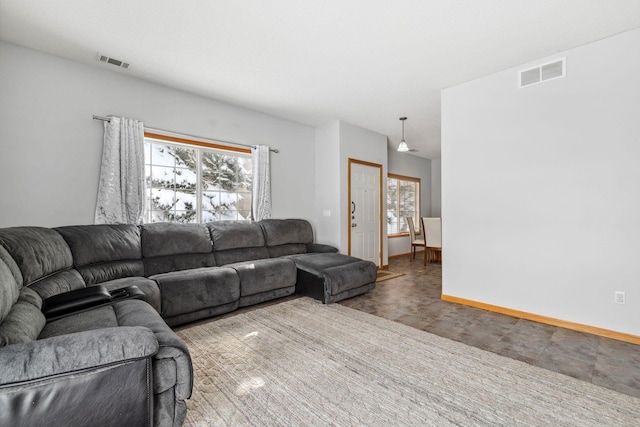 living room featuring plenty of natural light, visible vents, and baseboards