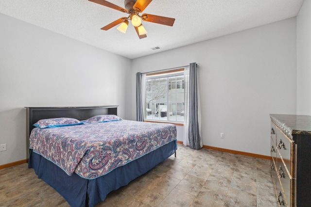 bedroom featuring a textured ceiling, ceiling fan, visible vents, and baseboards