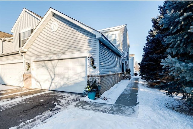 view of snowy exterior featuring brick siding