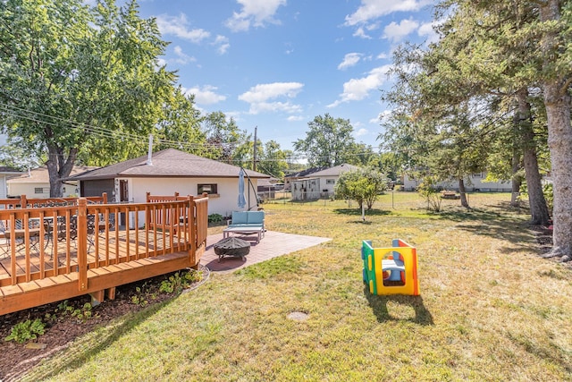 view of yard with an outdoor fire pit, fence, and a wooden deck