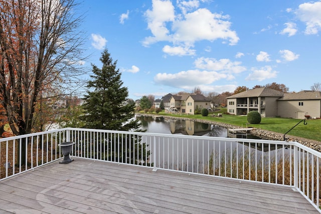 wooden terrace with a water view and a lawn