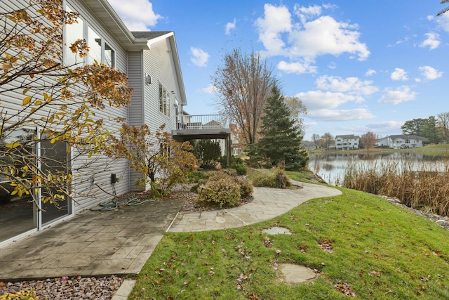 view of yard featuring a water view and a patio area