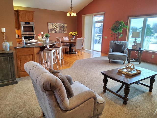 10590 Alamo St NE, Blaine, MN 55449 - living area with vaulted ceiling, light wood finished floors, light colored carpet, and a chandelier
