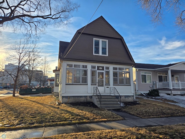 colonial inspired home with a sunroom and a gambrel roof