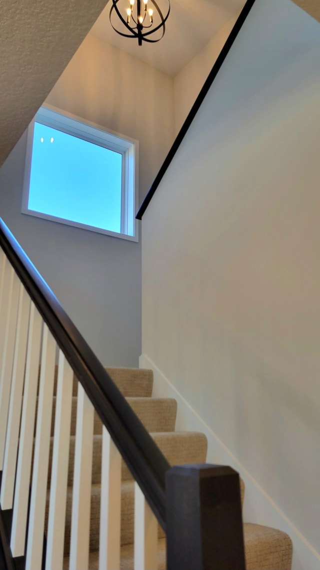 stairs with a chandelier