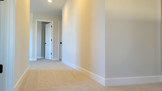 hallway with carpet floors and baseboards