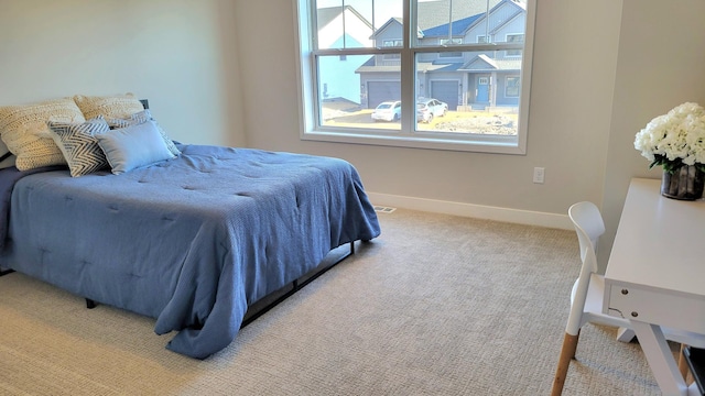 bedroom featuring baseboards and light colored carpet