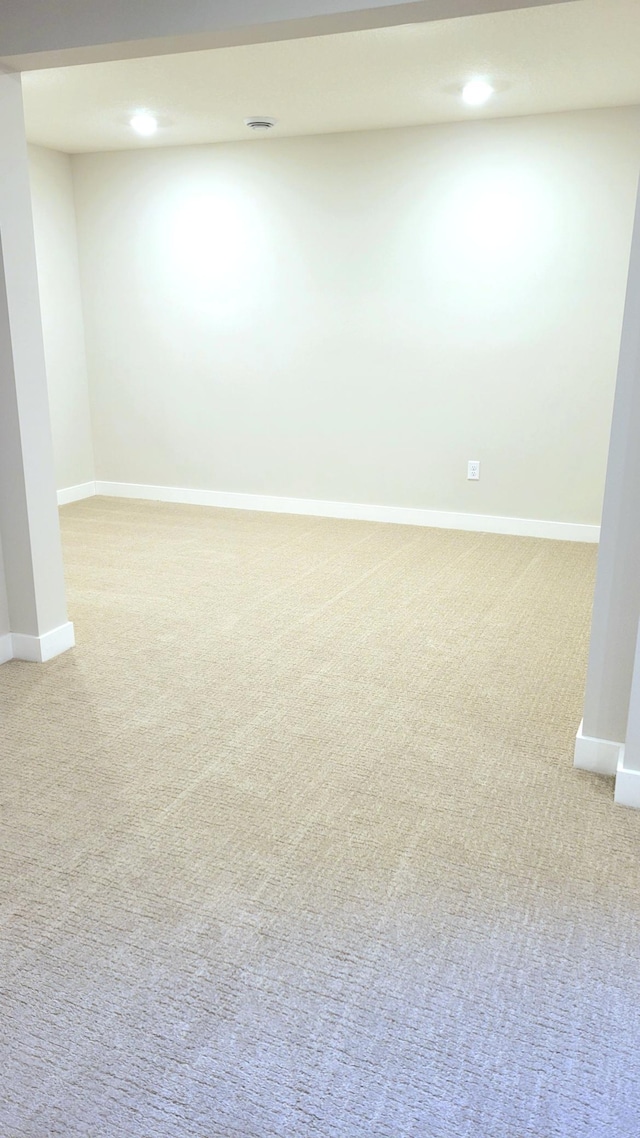 below grade area featuring recessed lighting, baseboards, and light colored carpet