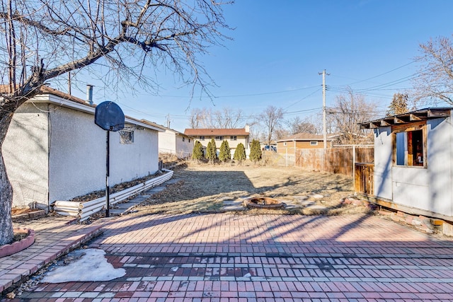 view of patio / terrace with an outdoor structure and fence