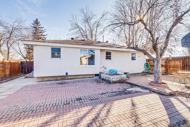 back of house with a patio area, a fenced backyard, and stucco siding