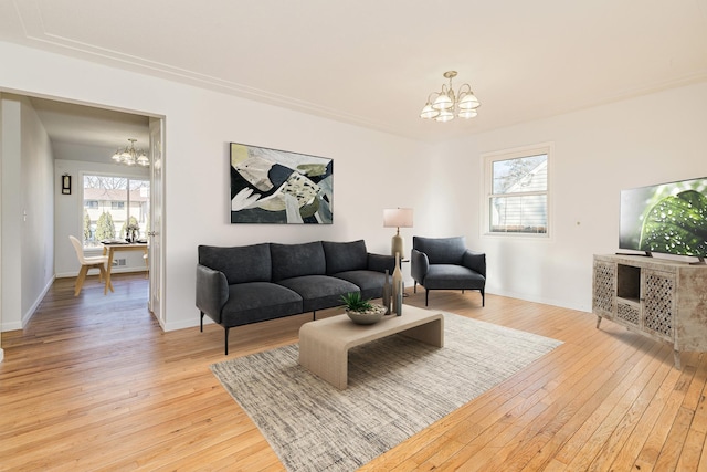 living room with a chandelier, plenty of natural light, and light wood-style floors