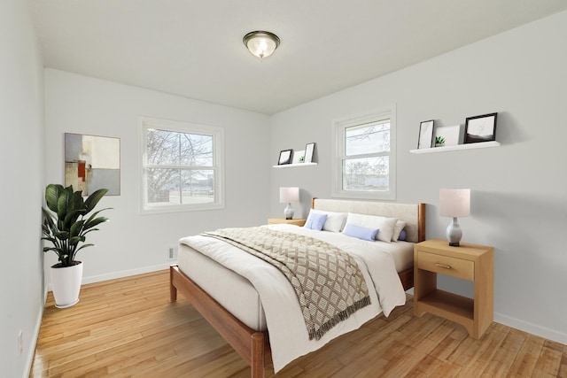 bedroom with light wood finished floors and baseboards