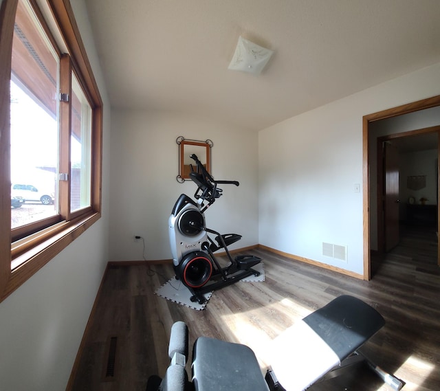 workout room featuring visible vents, baseboards, and wood finished floors