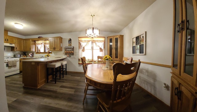 dining area with a wealth of natural light, a textured ceiling, an inviting chandelier, and dark wood-style flooring