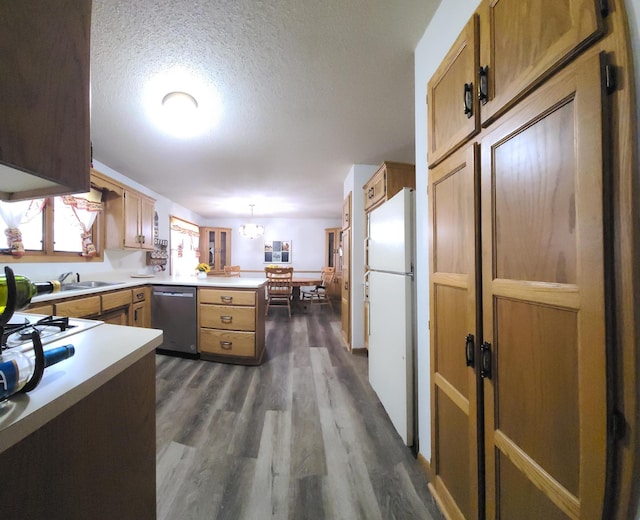 kitchen with a peninsula, dark wood-style flooring, freestanding refrigerator, light countertops, and stainless steel dishwasher