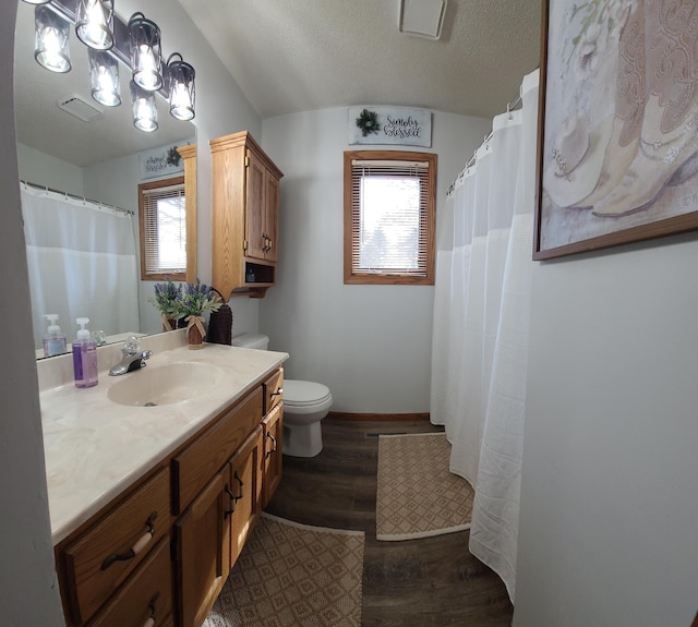 full bathroom with a healthy amount of sunlight, vanity, toilet, and wood finished floors