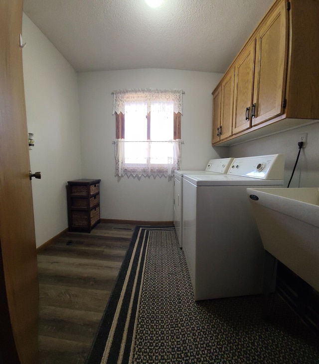 laundry room with washing machine and clothes dryer, baseboards, cabinet space, a textured ceiling, and dark wood-style flooring