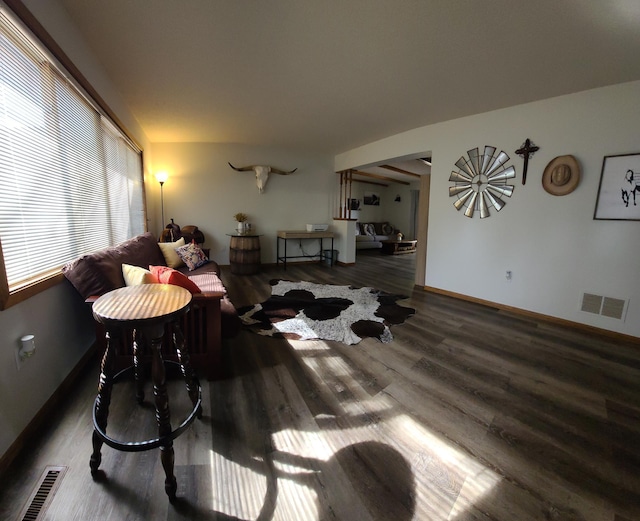 living area featuring visible vents, baseboards, and wood finished floors