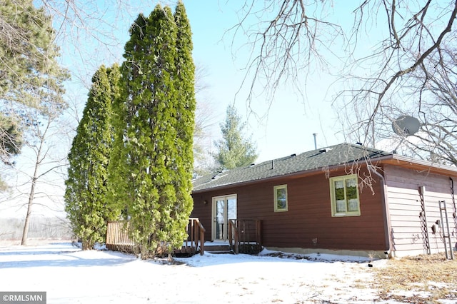 snow covered house with a deck