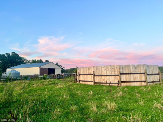 view of yard with an outbuilding, fence, and a pole building