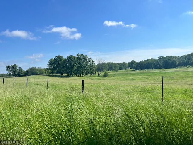 view of yard with a rural view and fence