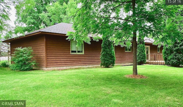 view of home's exterior with a lawn and roof with shingles