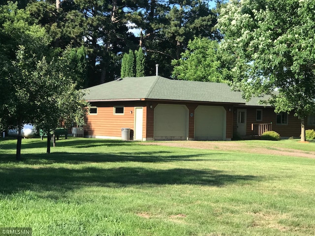 exterior space featuring a front lawn, a garage, and driveway