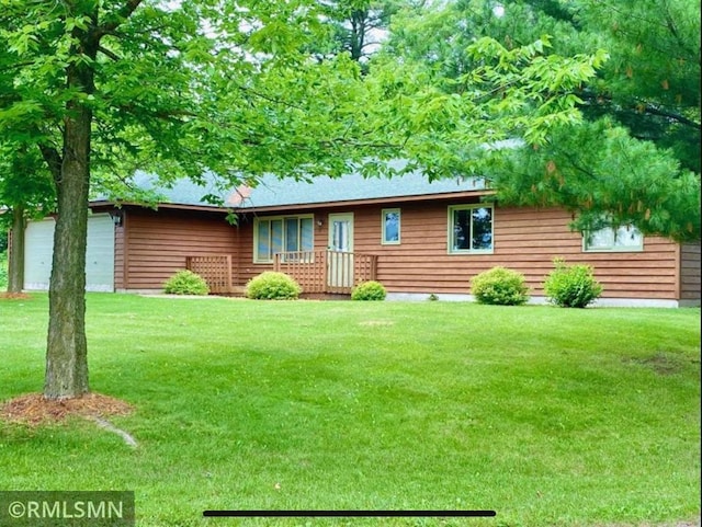 view of front of home with a front yard and a garage