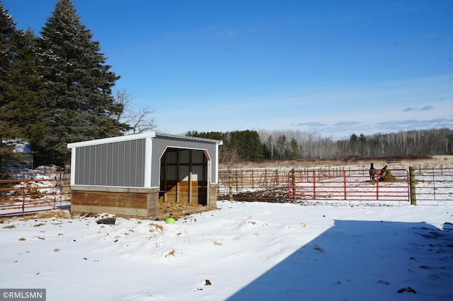 snowy yard featuring an outbuilding and fence