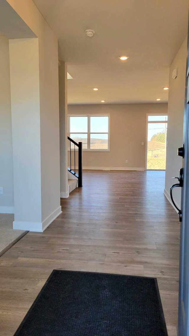 empty room with recessed lighting, wood finished floors, and baseboards